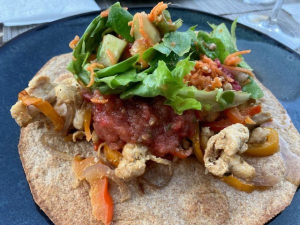 Volkoren tostada met gebakken kip, paprika, rode ui en tomaten vinaigrette